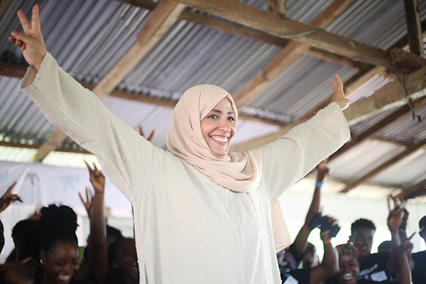 woman in front of a crowd holding up peace fingers