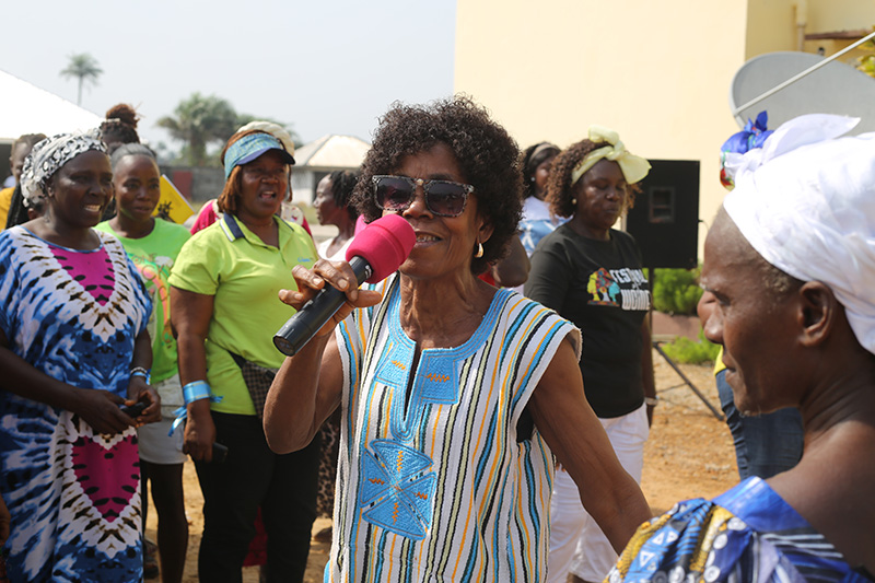 woman with a colorful dress speaking into a microphone
