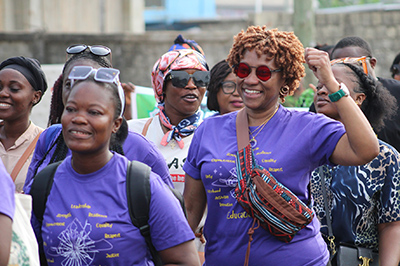 Two women in purple shirts in a crowd